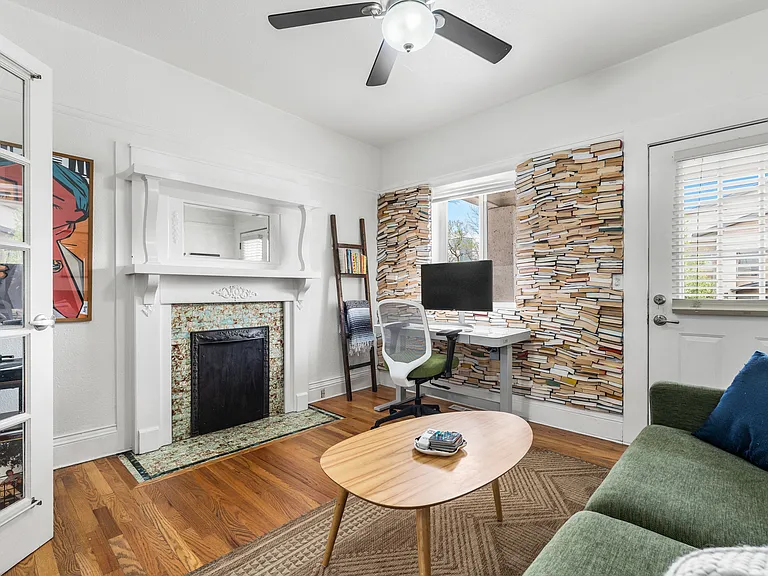Bright & open living space with a decorative fireplace and custom floor to ceiling library wall __