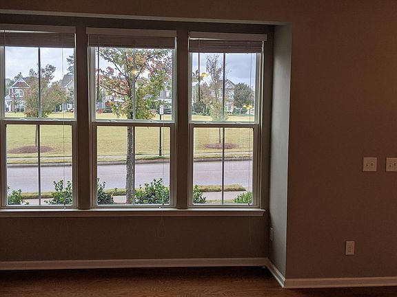 Large box window in the living room overlooking large open field.