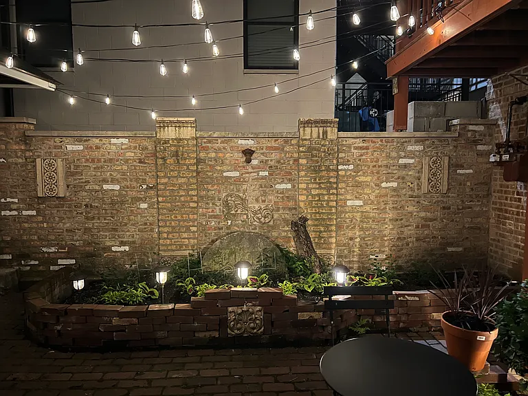 charming nighttime view of courtyard - doorway to the unit is out of view but to the right - european bistro courtyard surrounded by vintage brick