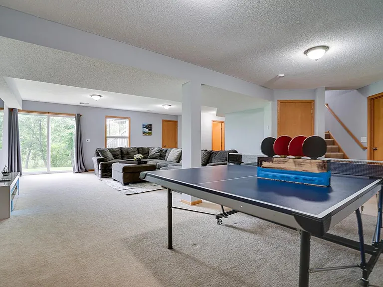 Another view of walk-out basement family room leading to large backyard with play set