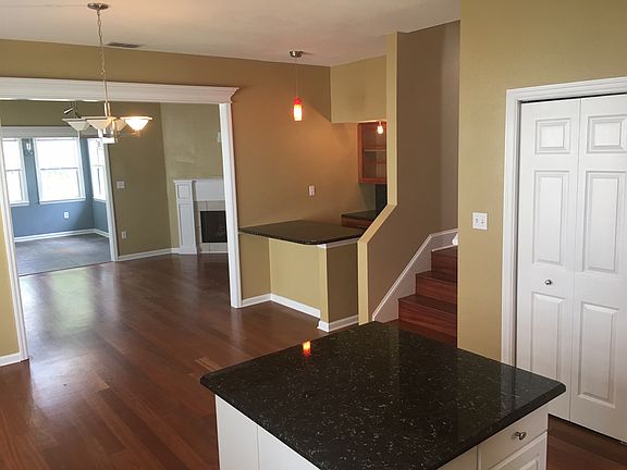 Bar with wine refrigerator and dining area between kitchen and family room
