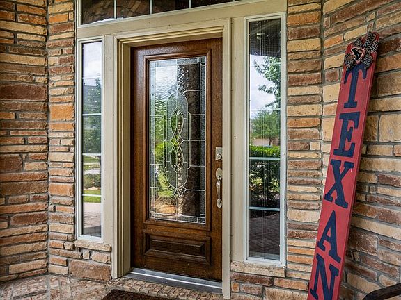What a WELCOME! The home has a stacked stone elevation, a covered wrap-around porch and leads into the beautiful home through a wood and lead glass front door.