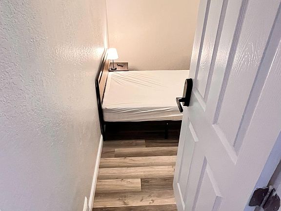 Furnished room near entrance and common area with work desk and relaxing space. Shared bath and on-site parking available.