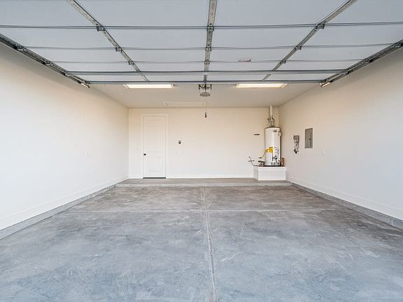 Empty, clean two-car garage with a closed overhead door, white walls, a gray concrete floor, a white