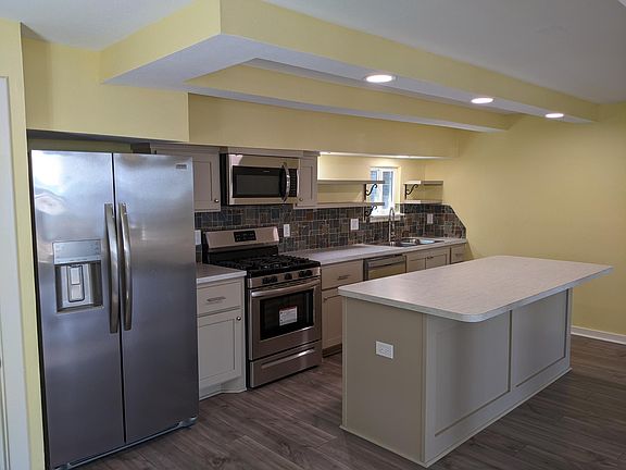 Kitchen island has an overhang perfect for bar stools. Appliances: refrigerator/freezer with ice & water dispenser, gas stove & oven, microwave, and dishwasher.