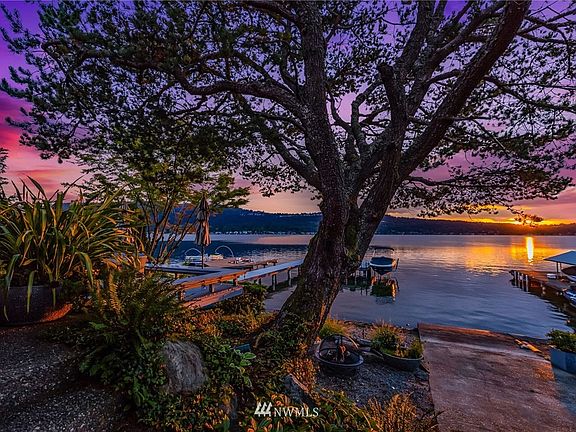 Enjoy spectacular sunsets from the home, deck and dock - mature landscaping keeps the setting very private
