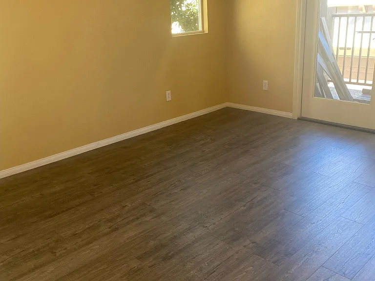 Primary bedroom with new floors and french doors leading out to balcony.
