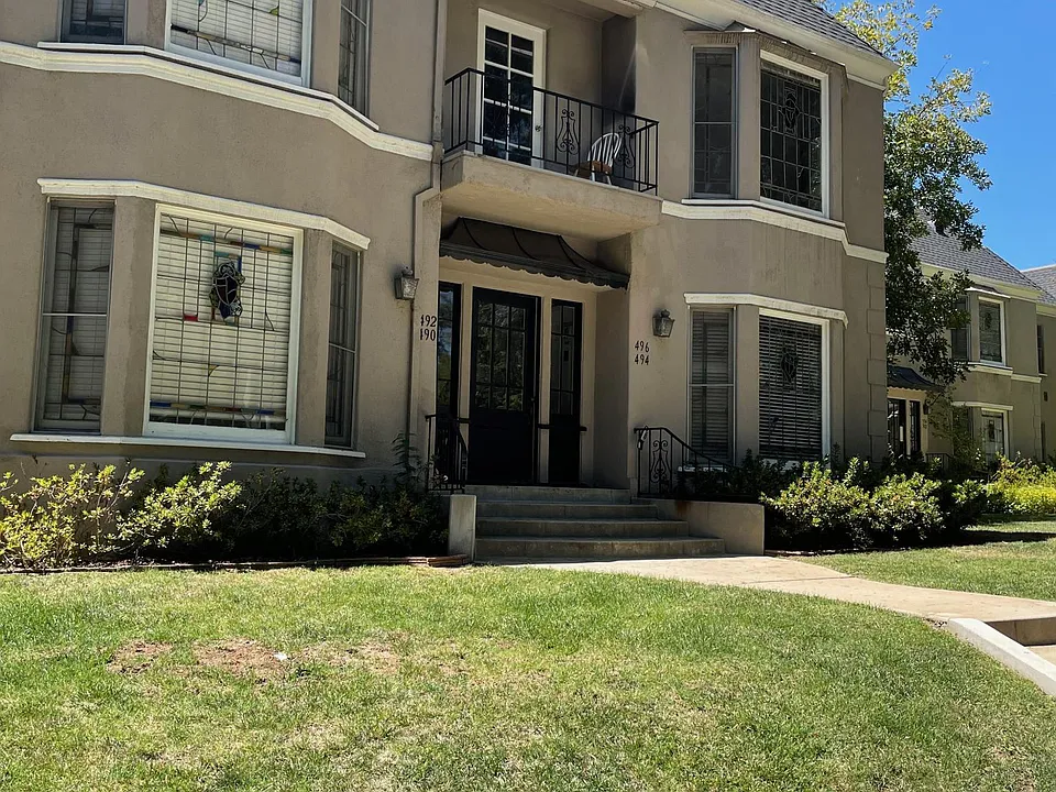 Front of property showing vintage stain glass in bay windows of Orange Grove Apartments in Pasadena, CA.