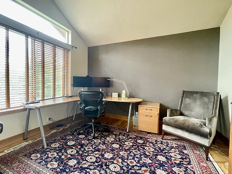 Home office with vaulted ceilings and large windows facing the street so you can watch the kids come home from school