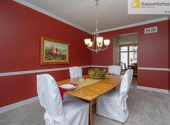Dining room has chair rail, crown molding, and bay window.