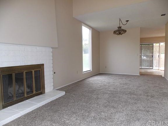 Living room opens to formal dining room with floor to ceiling window