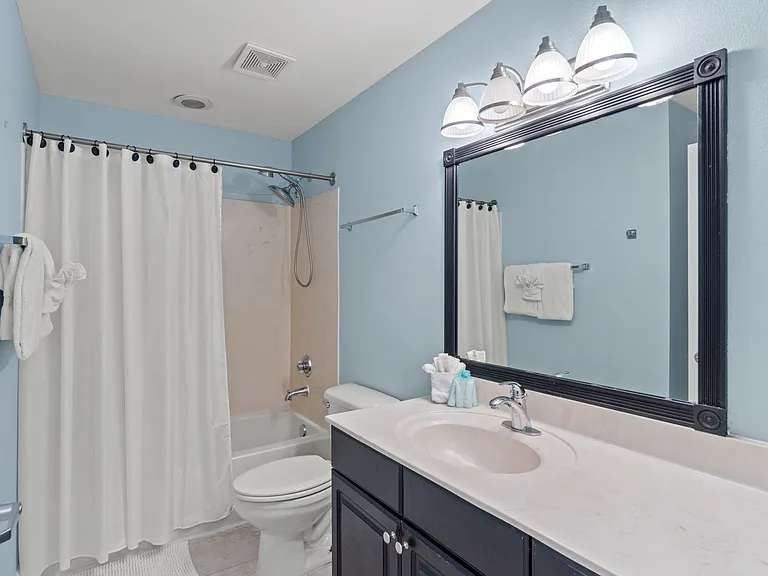 The first guest bedroom has an ensuite tub/shower combination and vanity.