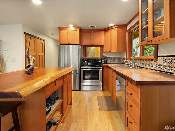 The kitchen has SS appliances, beautiful wood cabinets,  Sapelle wood island counter-top, Herringbone inlay and tile backsplash.