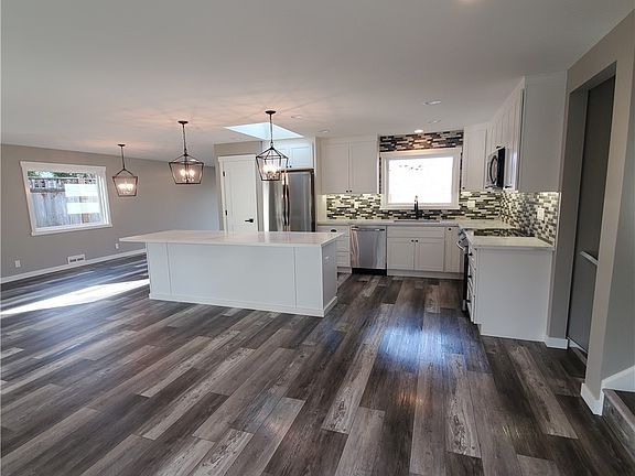 Open floor plan.  Quartz countertops, tile backsplash, eating bar, brand new stainless steel appliances, under-cabinet lighting, and LVP flooring.