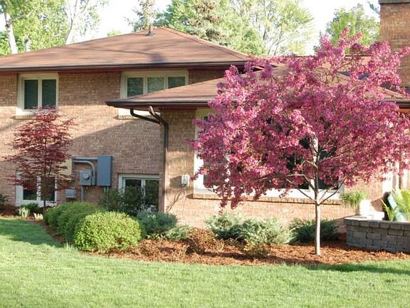 Green grass and blosoms...You will enjoy this private fenced back yard every season of the year.
