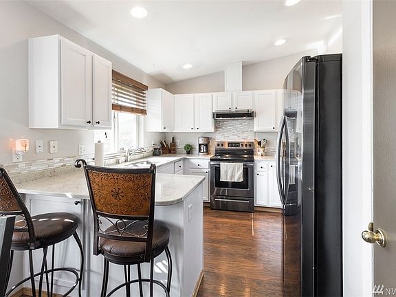 The kitchen has been refreshed with new quartz counter tops, new backsplash, new sink and faucet, new flooring and freshly painted cabinets! The dishwasher and stove are new! The refrigerator is just 2 years old! It all stays!