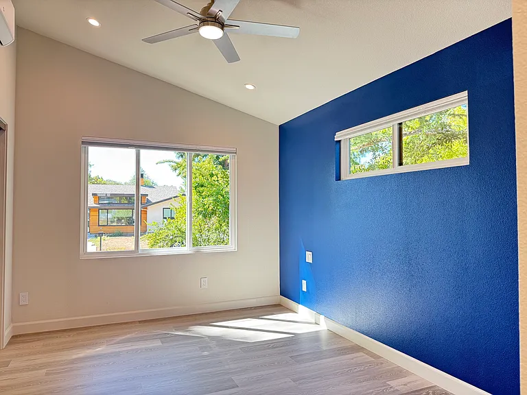 Main bedroom suite with vaulted ceilings, recessed lighting, overhead fan, blackout shades and large closet with built in cabinet organizer.