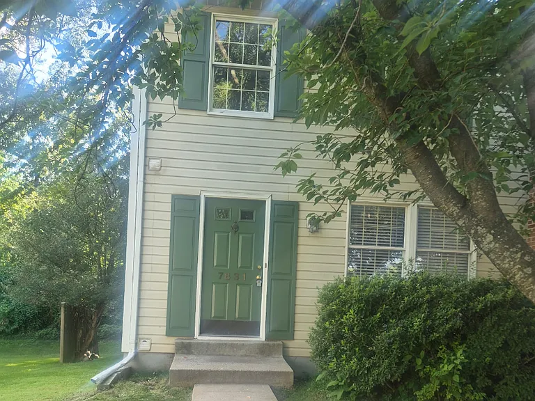 Front of Home featuring mature trees and landscaping.
