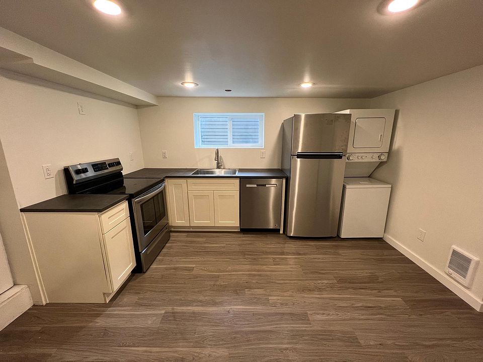 Modern, updated kitchen with stainless steel appliances and in-unit washer/dryer. New flooring, paint, cabinets, and countertops. Floating shelving over cabinets (not pictured).