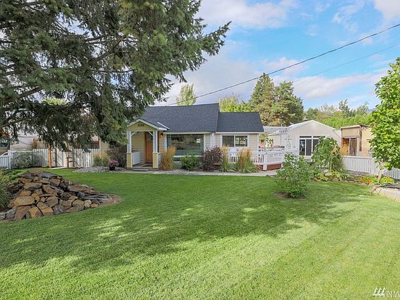 Manicured fenced mature front yard.