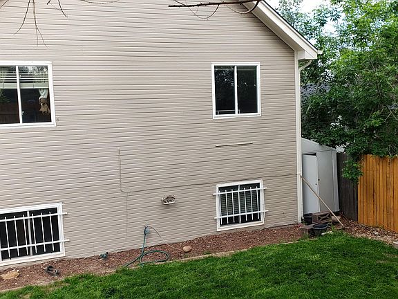 Back of house, green lawn, new fence