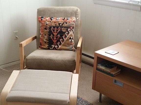 The rocking chair and ottoman face the sofa