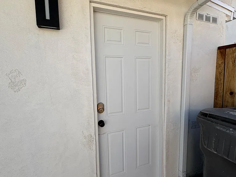 smart lock and modern lighting by side door to garage