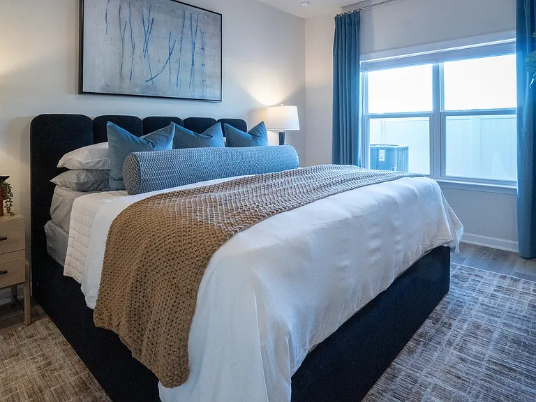 Primary bedroom on the main level, with king size bed and large window letting in a ton of natural light.