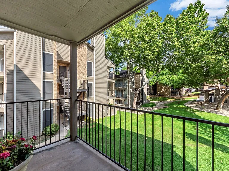 Private patio or balcony overlooking landscaped community grounds