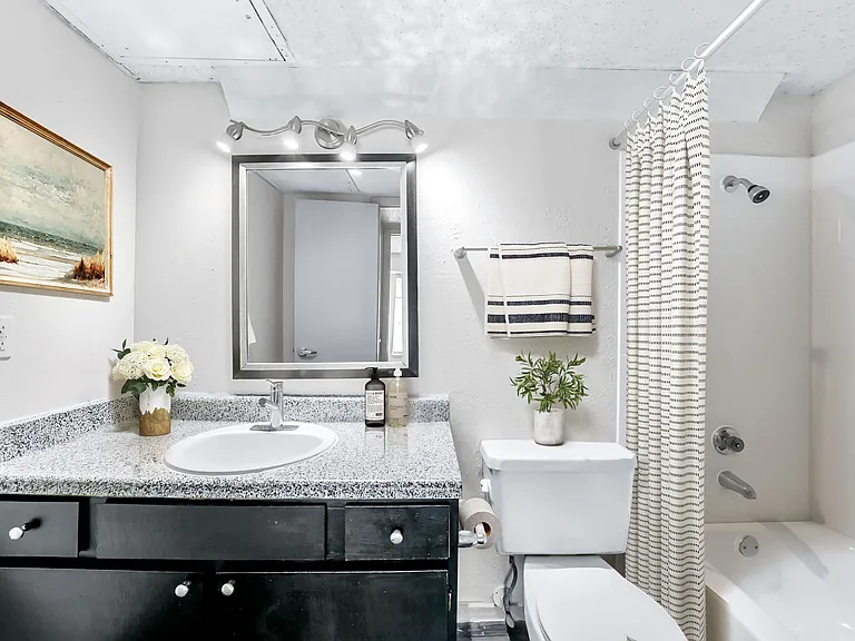 A1 Bathroom w/ Black Cabinetry & Framed Mirror