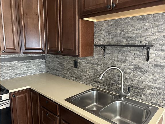 This is a close up of the sink and counter. The stove is gas.