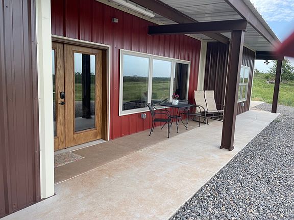 Front double door and large window. Outside patio area with patio table and chairs.