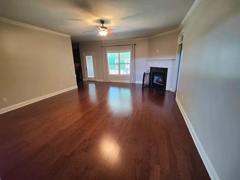 Living room with door and window to back porch, fireplace.