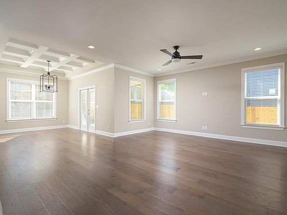 Open floorplan with detailed ceiling in dining room. Ceiling fan and recessed lighting in living room.