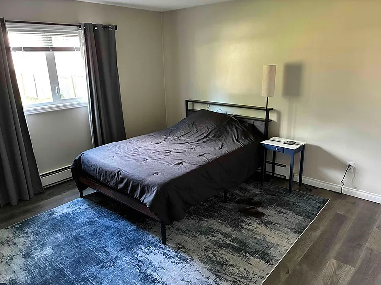 Queen sized bed in a large bedroom
