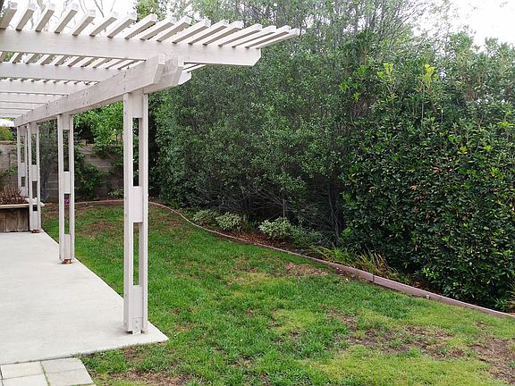back yard with large trellised patio