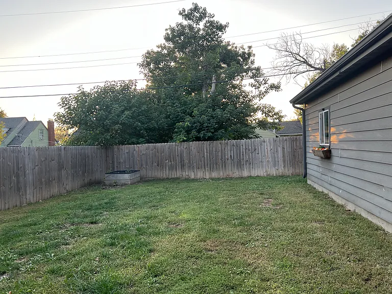Fully fenced back yard with raised garden bed
