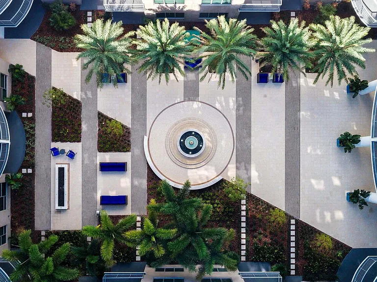 Stroll through the serene courtyard, where palm trees create a peaceful escape right outside your door.