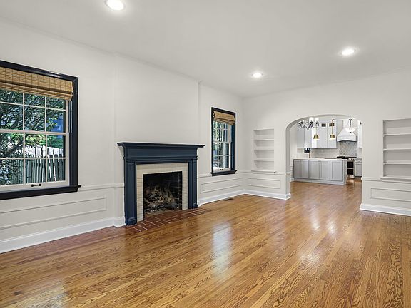 Bright living room with fireplace, built-ins, and hardwood floors.