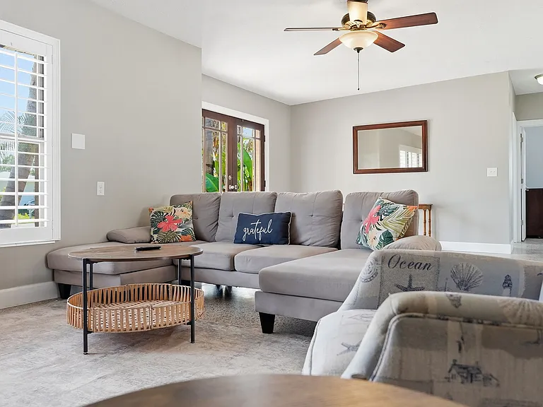 Living area includes comfortable couch, recliner with lots of natural light from windows. Also has 65 inch TV.