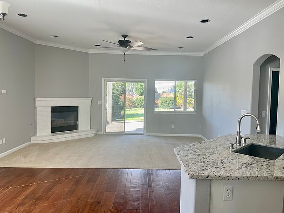 Open living area with fireplace. Opens to covered patio and beautifully landscaped backyard.