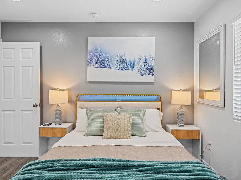 The bedroom has a cozy bed, soft lighting, and a peaceful setting_great for resting.