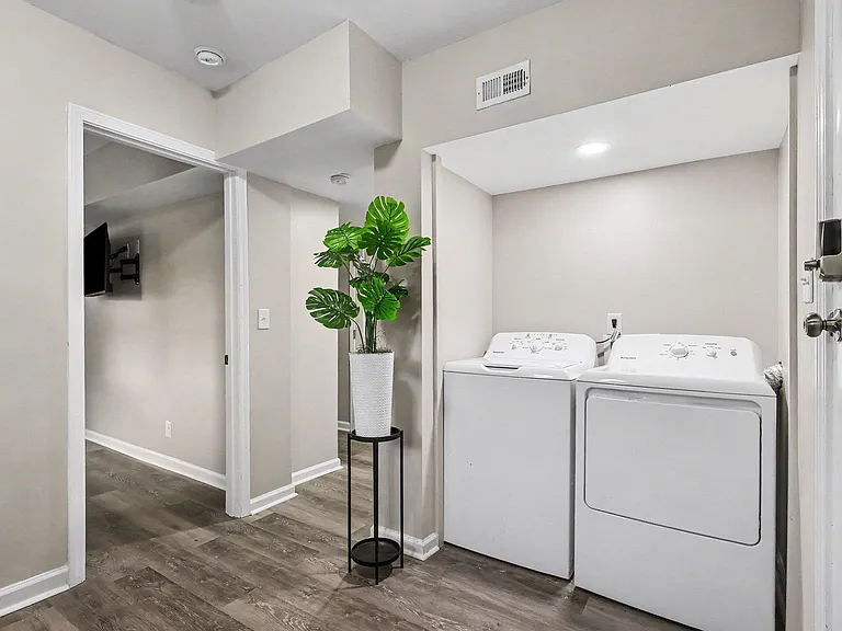 Convenient in-home laundry area with a full-size washer and dryer, plus easy access to the adjacent hallway.