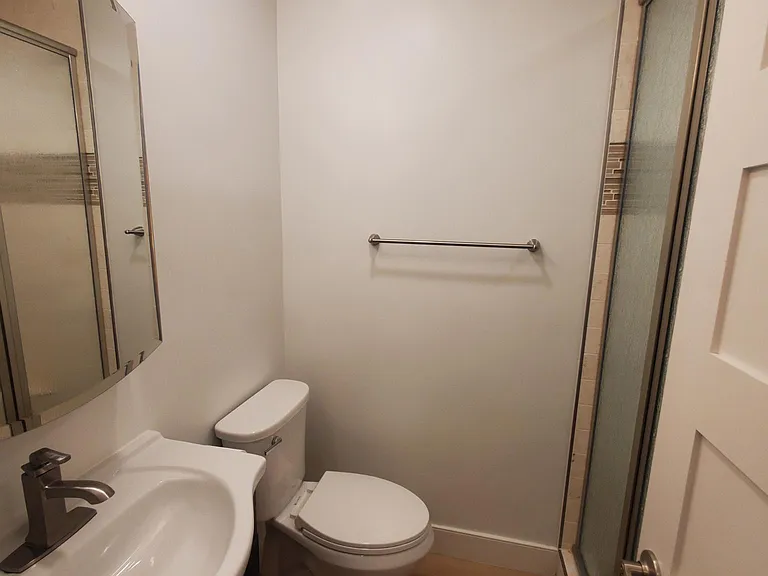 Bathroom #3 with new mirrored medicine cabinet, sink, vanity, lights, toilet, shower tile and doors