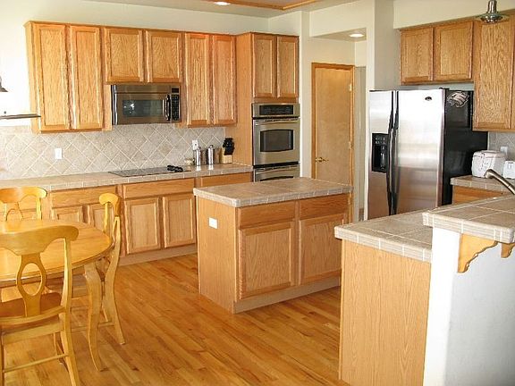 Gourmet kitchen with wood floors, tile counters, 42inch cabinets