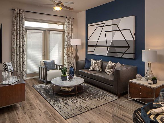 Living area with accent wall, wood like floors, double doors to patio, and typical furniture
