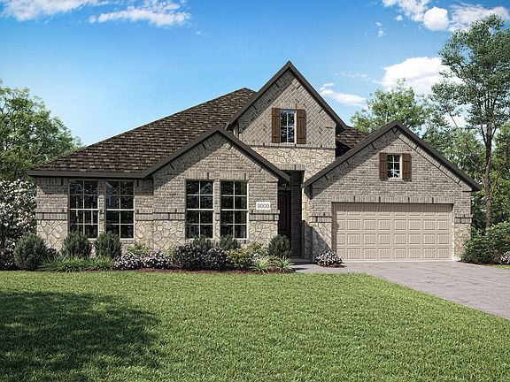 A two-story brick house with a gabled roof, surrounded by lush green grass and trees, stands in a we