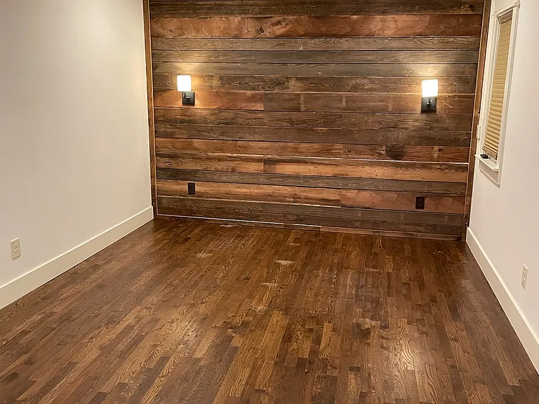 Primary suite with wall sconces on 150 year old heart pine