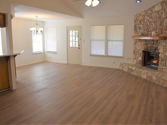 View of the open concept living/dining/kitchen with corner fireplace.