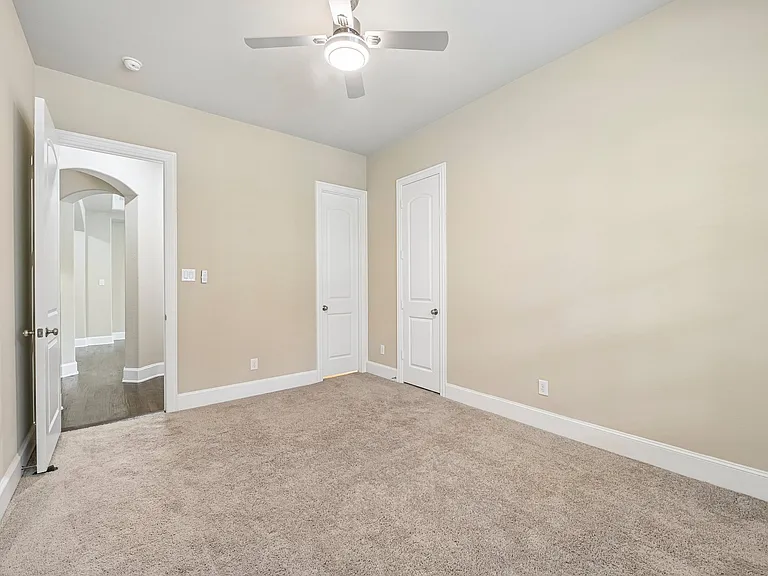 Downstairs guest bedroom with a ceiling fan.